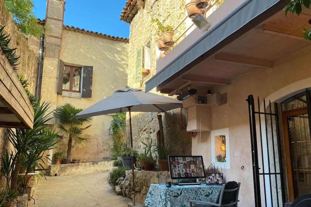 a table with an umbrella next to a building at historic authentic atmosphere - high-end luxury décor in Le Cannet