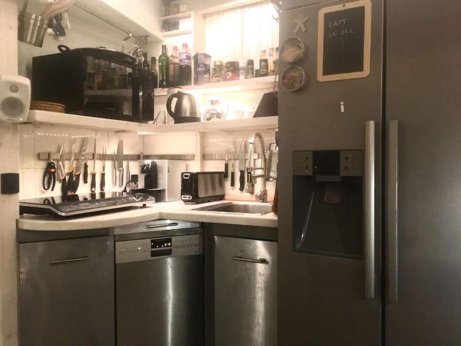 a kitchen with a stainless steel refrigerator and a sink at historic authentic atmosphere - high-end luxury décor in Le Cannet