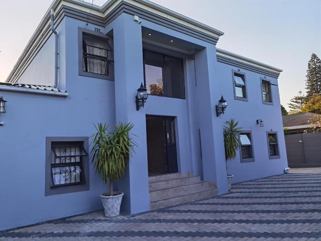 a blue house with plants in front of it at Victoria Guest Lodge in Bellville