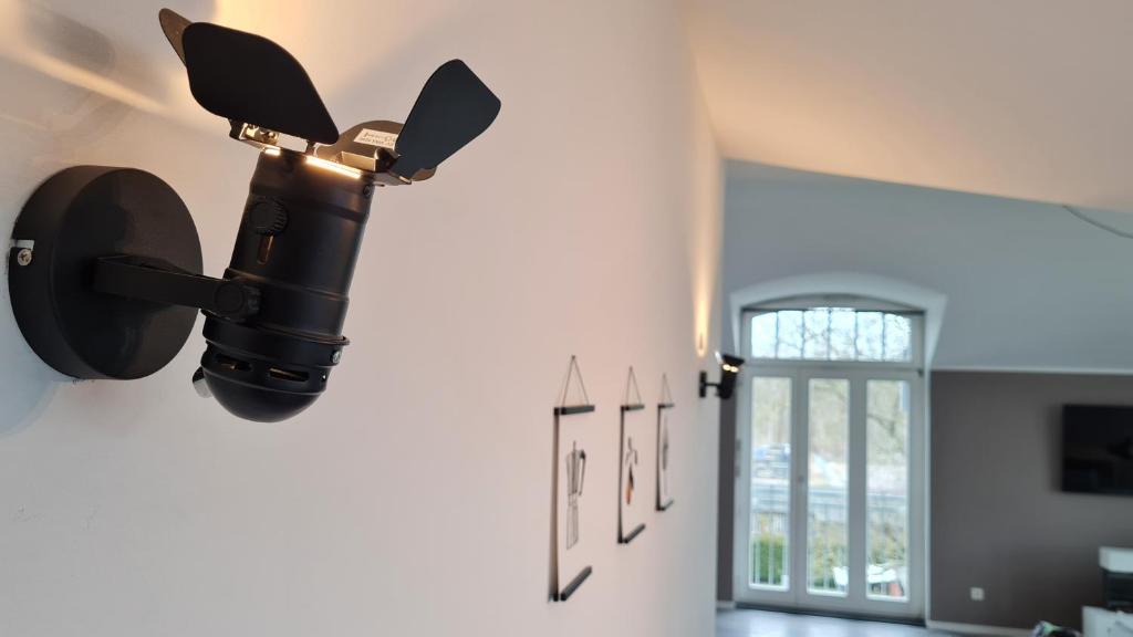 een lamp aan een muur in een kamer bij Penthouse in Villa am Wasser + Parken + WLAN + Netflix +Kamin in Wildau