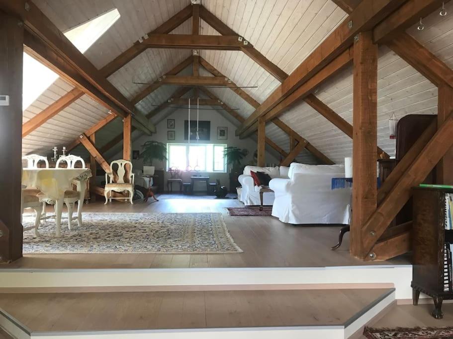 uma ampla sala de estar com tectos de madeira e vigas de madeira em Villa Verstas Karjalohja em Karjalohja