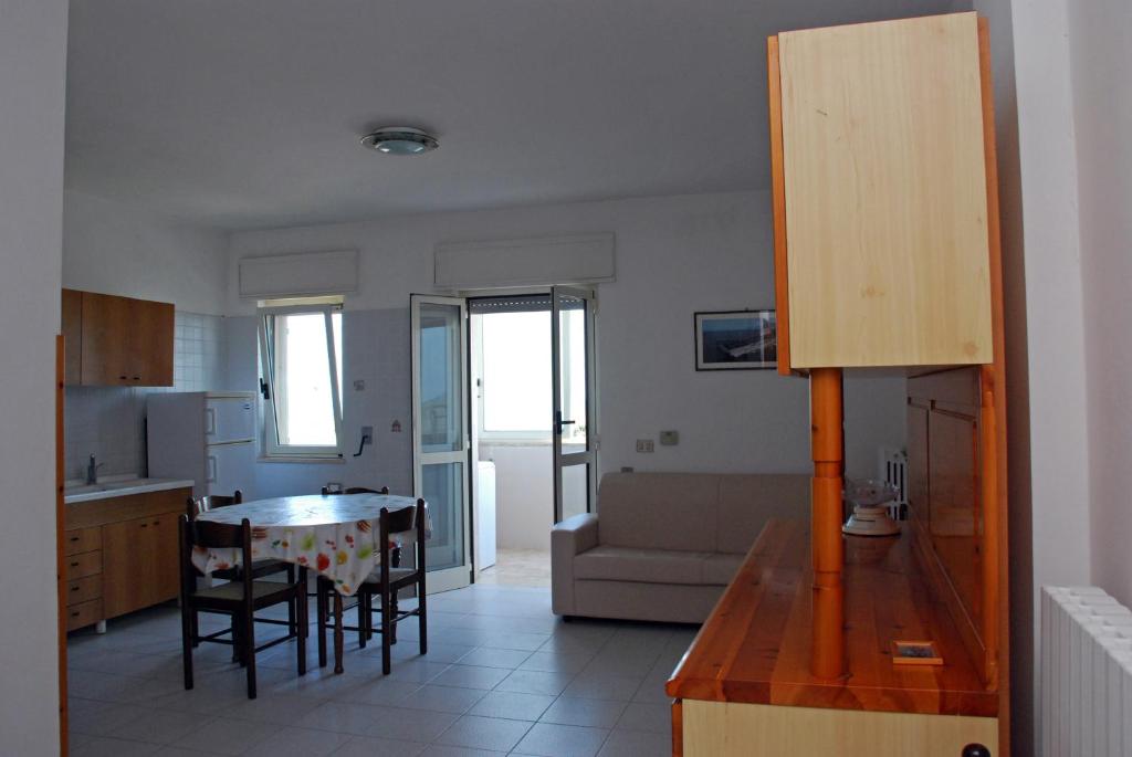 eine Küche und ein Wohnzimmer mit einem Tisch und Stühlen in der Unterkunft Bella Otranto in Otranto