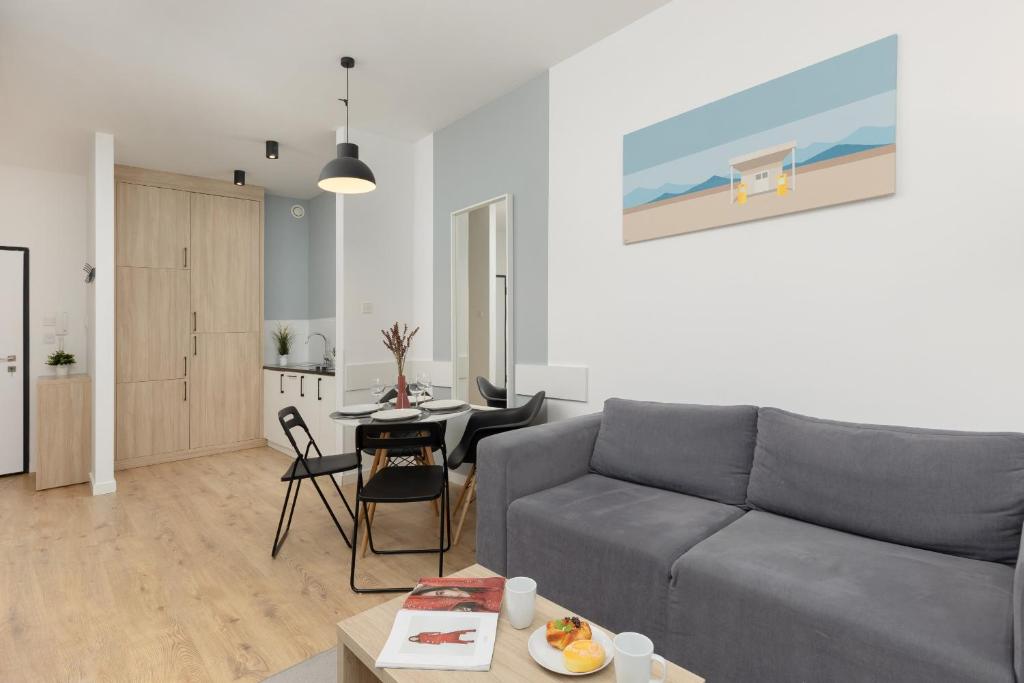 a living room with a couch and a table at Wola Pet-friendly Apartments with AC Sławińska by Renters in Warsaw