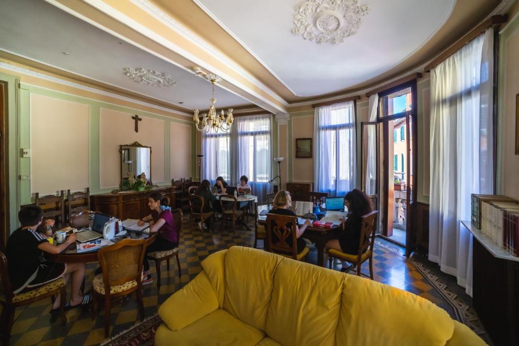 un gruppo di persone seduti ai tavoli in un ristorante di Ostello Domus Civica a Venezia