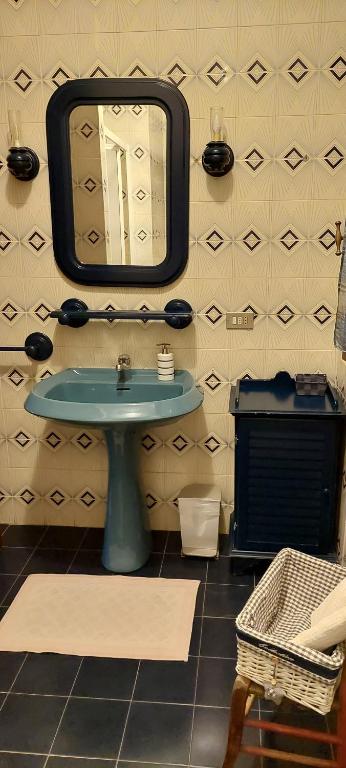 baño con lavabo y espejo en la pared en Ca Angiola, en Moglia