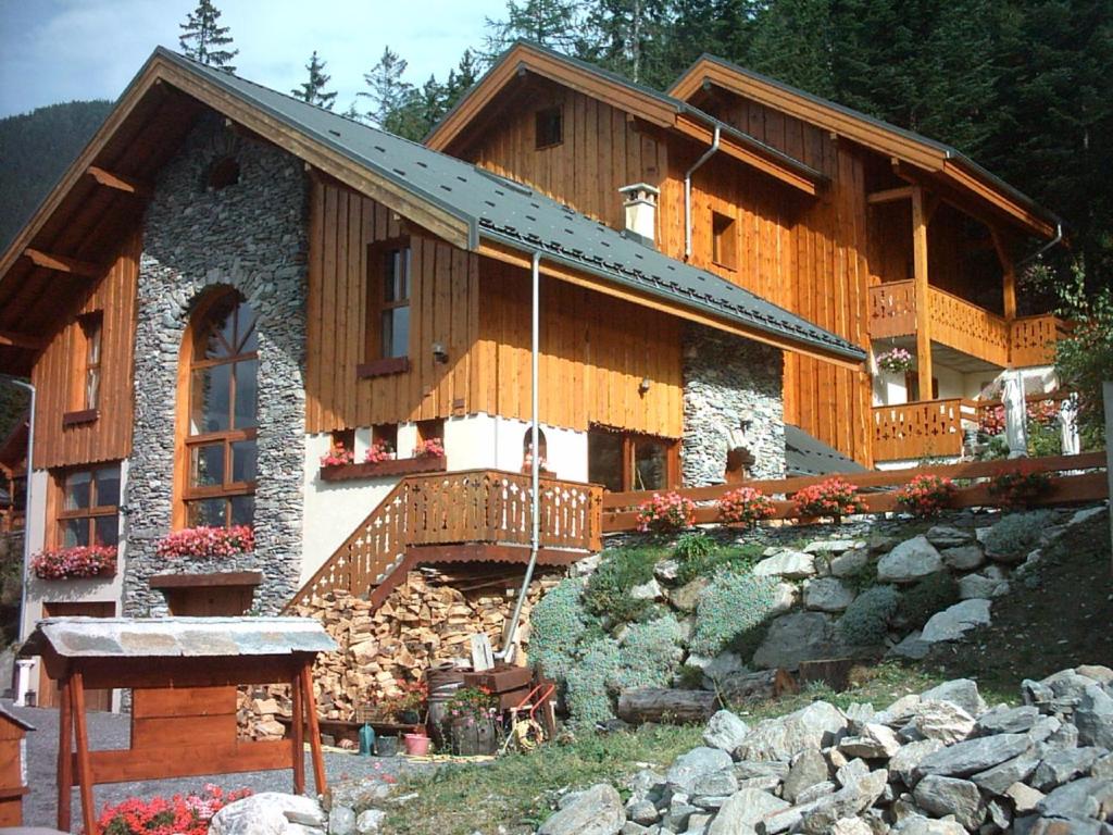 a large wooden house with a balcony on a hill at Chalet Deleglise 1 in Valfréjus