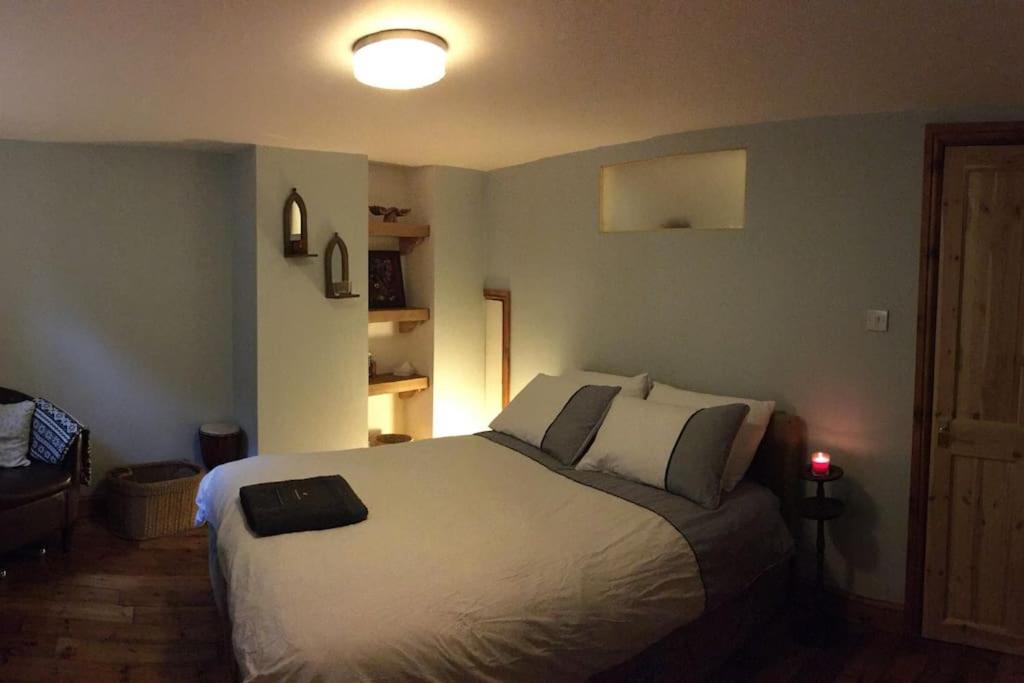 um quarto com uma grande cama branca e uma luz sobre ela em The Quirky, cosy hideaway! An apartment close to Leeds City Centre em Amley