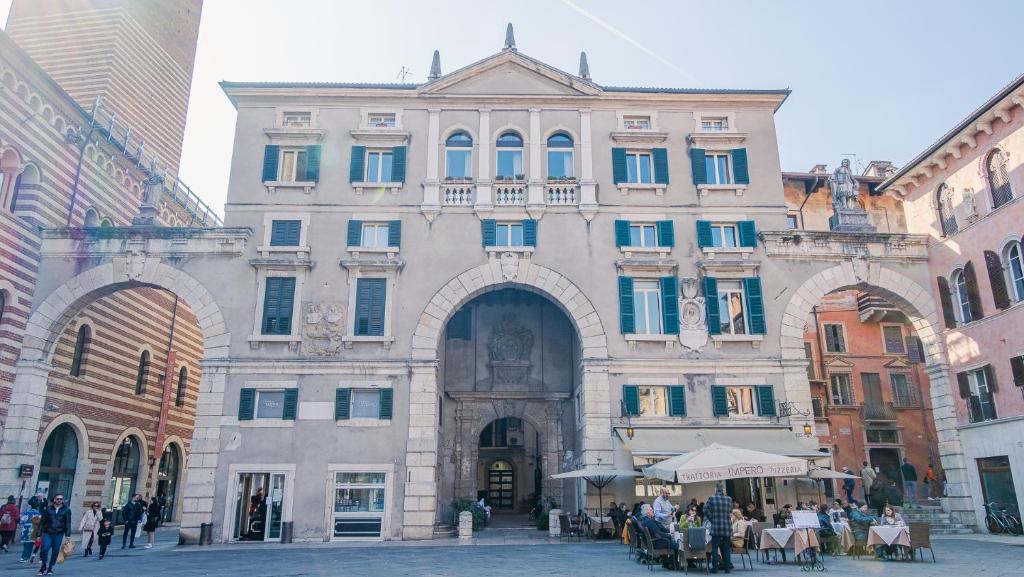 un gran edificio con gente sentada frente a él en Domus Nova Palace - Italian Homing, en Verona