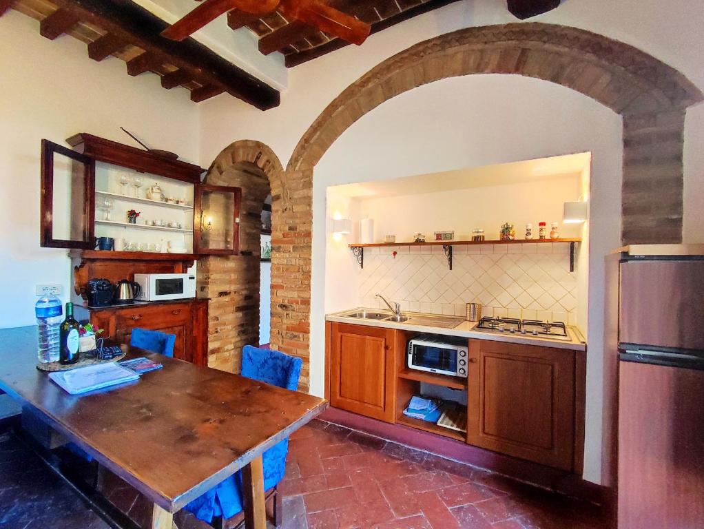 cocina con mesa de madera y encimera en Convento San Gimignano Apartments, en San Gimignano