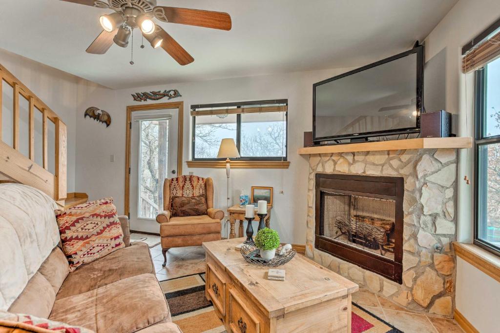 ein Wohnzimmer mit einem Kamin und einem TV in der Unterkunft Medicine Park Cabin Rental with Mountain View in Medicine Park
