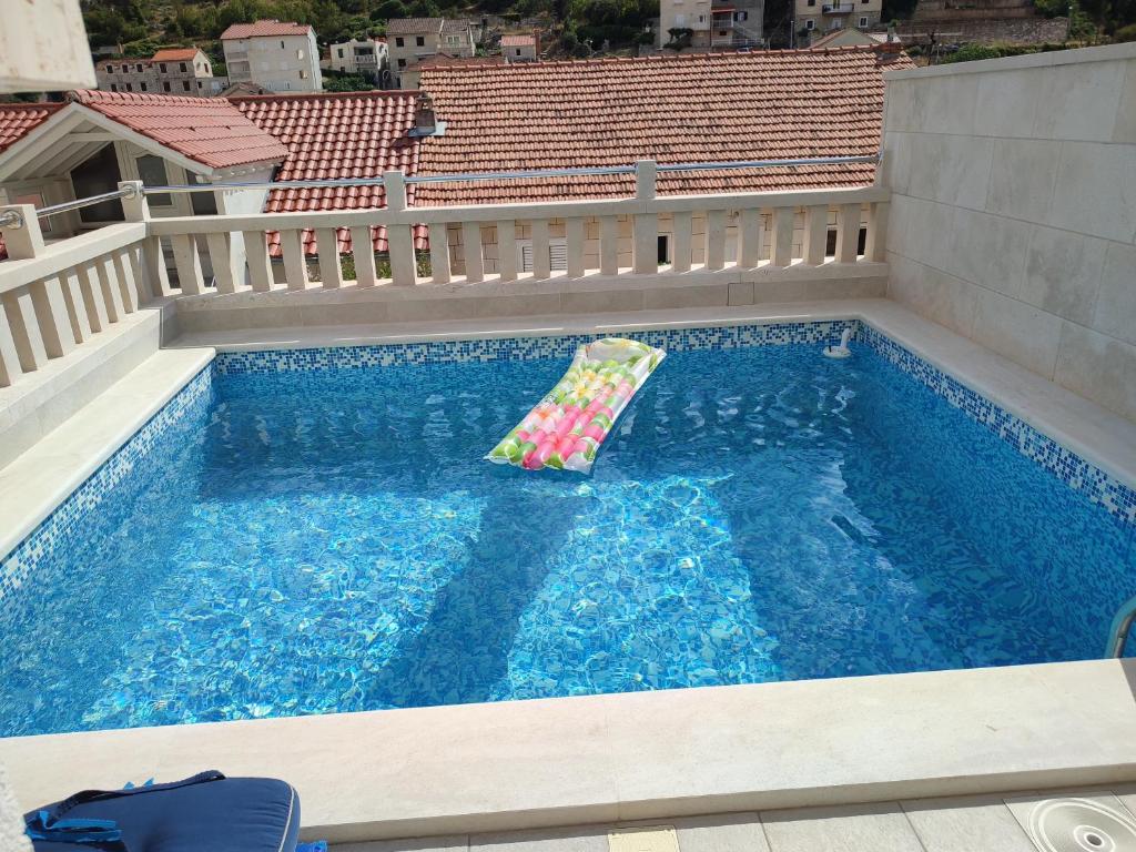 a swimming pool with a chaise lounger in the water at Apartment Making memories in Pučišća