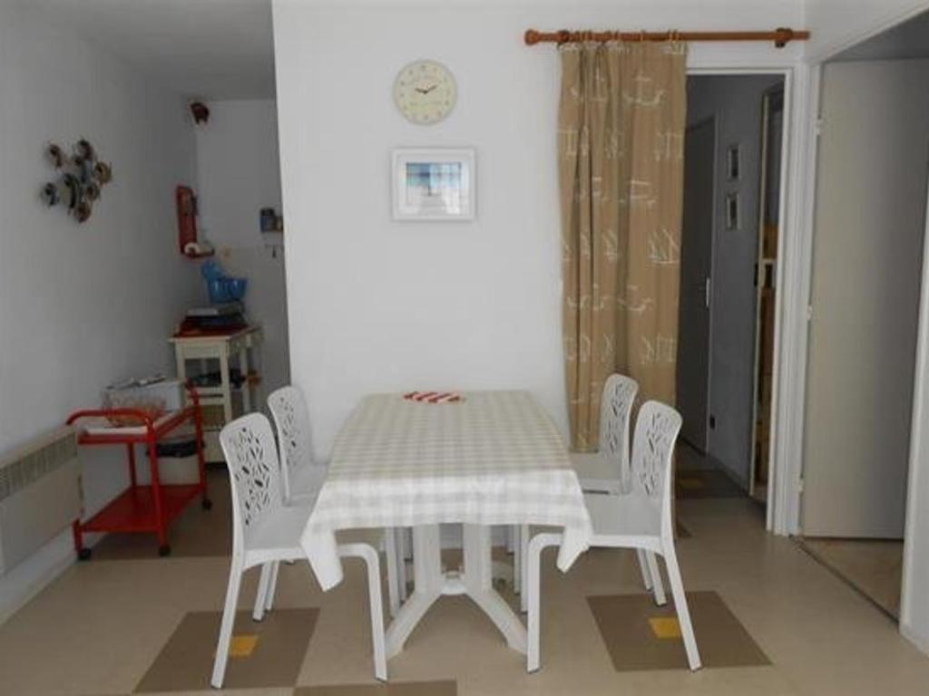 サンティレール・ド・リエにあるAppartement Saint-Hilaire-de-Riez, 2 pièces, 4 personnes - FR-1-324-146の白いテーブルと椅子、テーブルと椅子が備わる客室です。