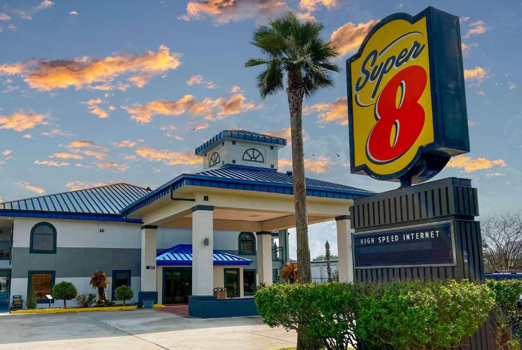 a shell gas station with a palm tree in front of it at Super 8 by Wyndham Sealy in Sealy
