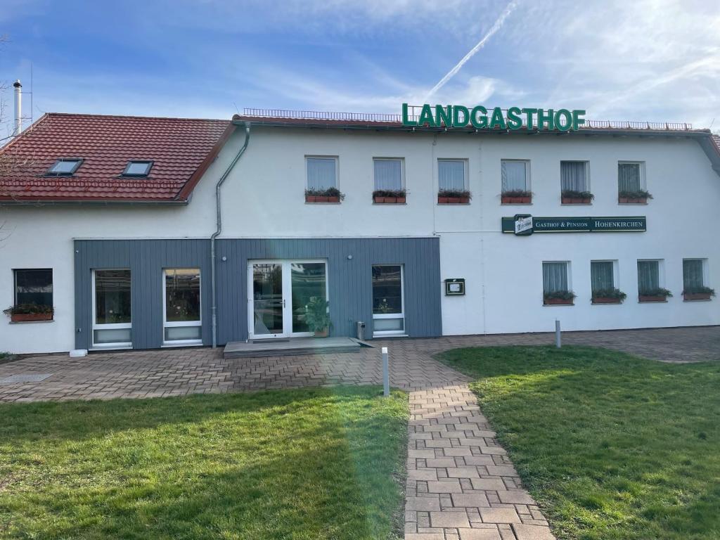 un edificio blanco con un cartel encima en Landgasthof und Landpension Hohenkirchen, 