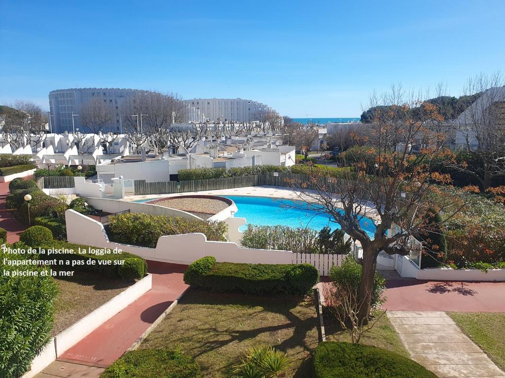 - une vue sur la piscine dans le jardin dans l'établissement Le studio mer, piscine et soleil, à La Grande Motte