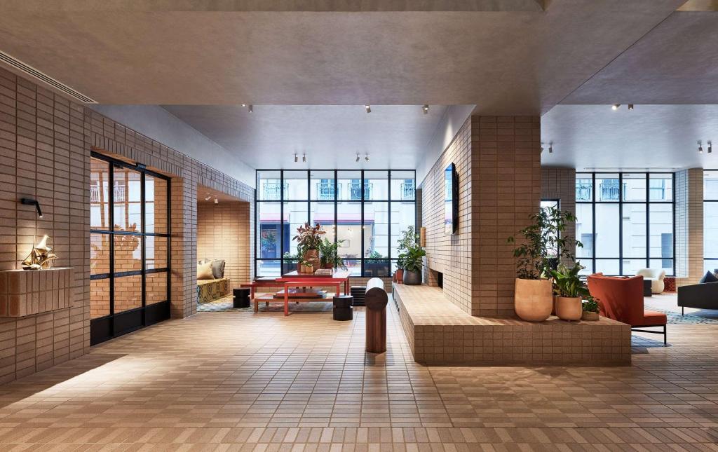 un hall d'un bâtiment avec des fenêtres et des plantes dans l'établissement Hyatt Centric Melbourne, à Melbourne