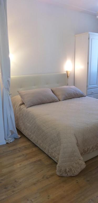 Cà Comare Burano في بورانو: غرفة نوم مع سرير أبيض كبير مع نافذة