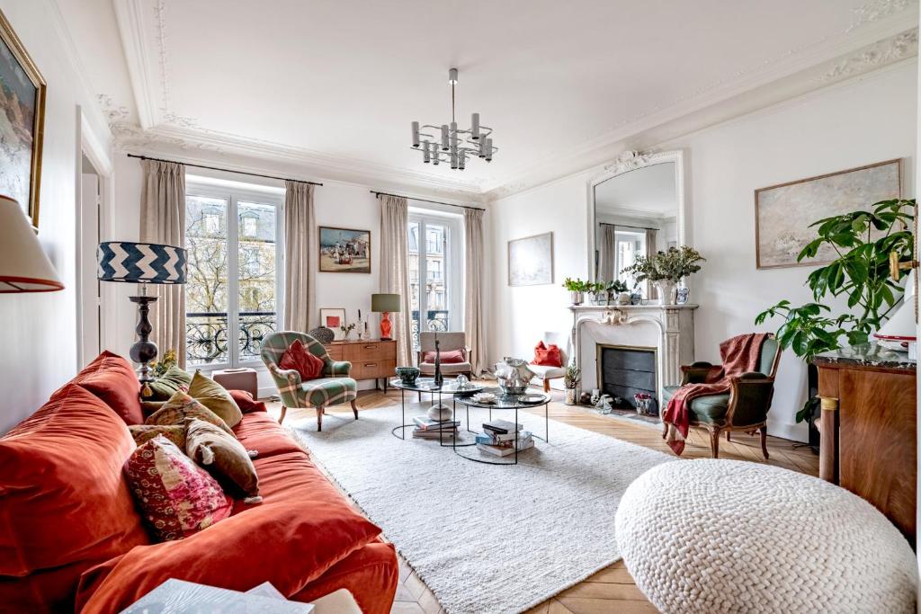 a living room with a red couch and a fireplace at Veeve - The Hopeful Romantic in Paris