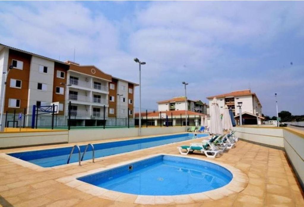une grande piscine avec des chaises et un bâtiment dans l'établissement Remarkable 3-Bed Apartment in Viana, à Viana