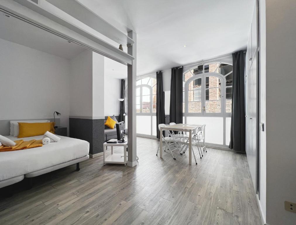 1 dormitorio con 1 cama y 1 mesa con comedor en Stay U-nique Apartments GranDeGracia, en Barcelona
