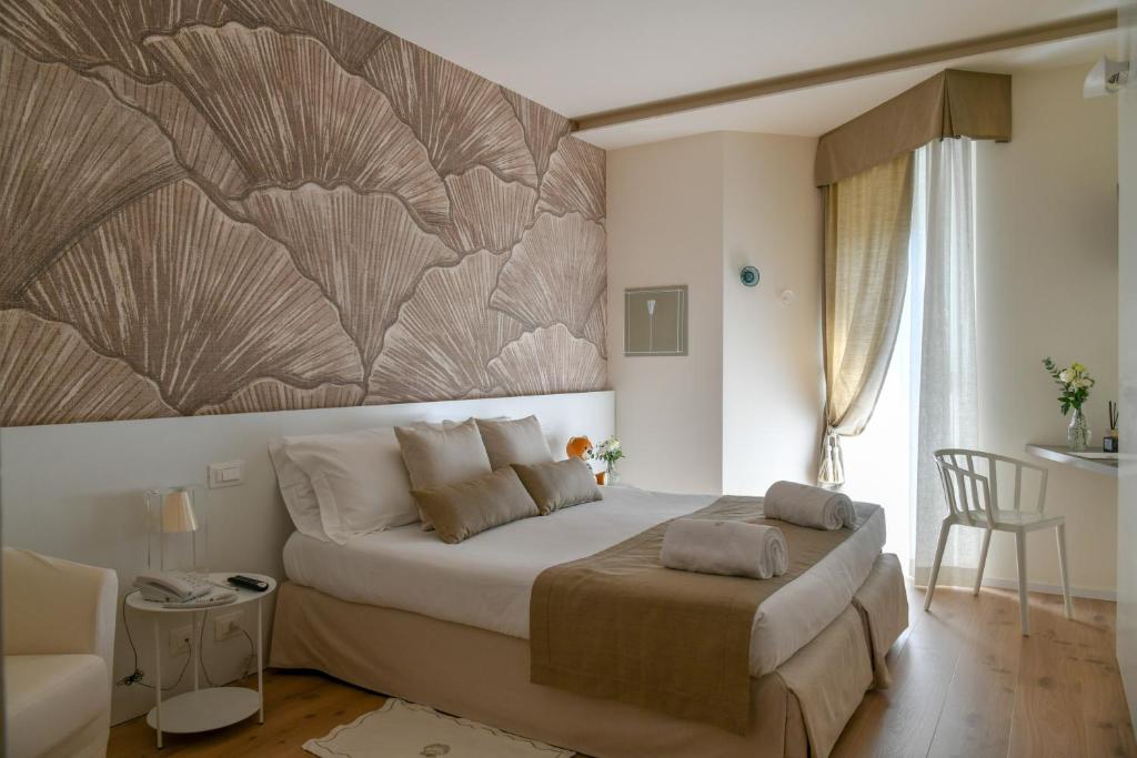 een slaapkamer met een bed en een grote muurschildering bij Hotel Elite in Lido di Jesolo