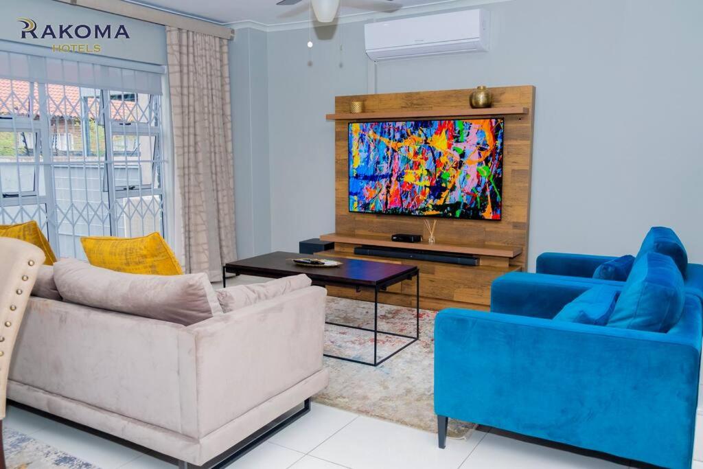 a living room with two couches and a tv at Deluxe 3 Bed Apartment in Polokwane