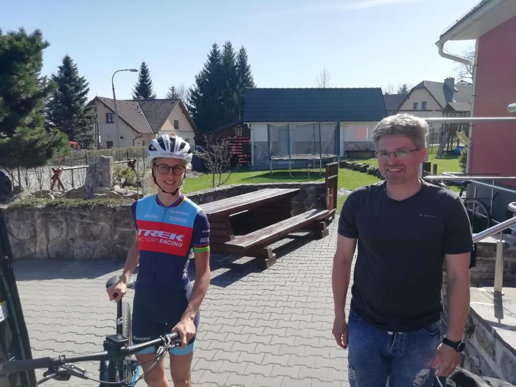 a man standing next to a boy holding a bike at Red Pine Apartments in Vlachovice