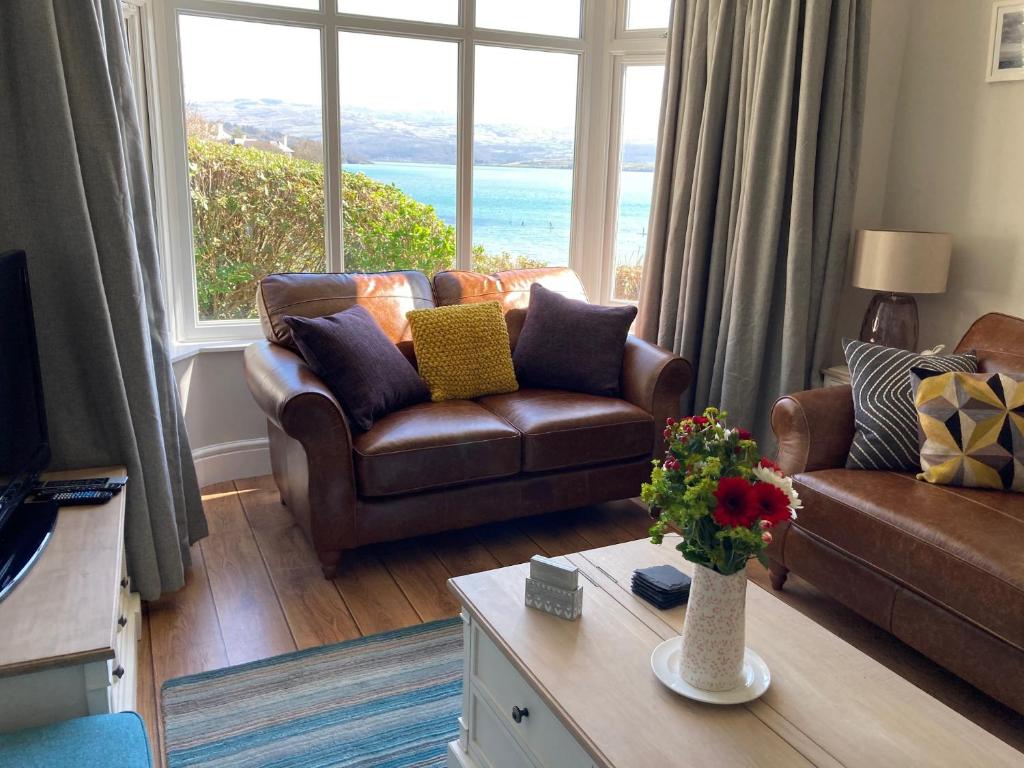 a living room with a couch and a large window at Tegfryn (Sleeps 8), 5*, Sea View, Borth y Gest in Porthmadog