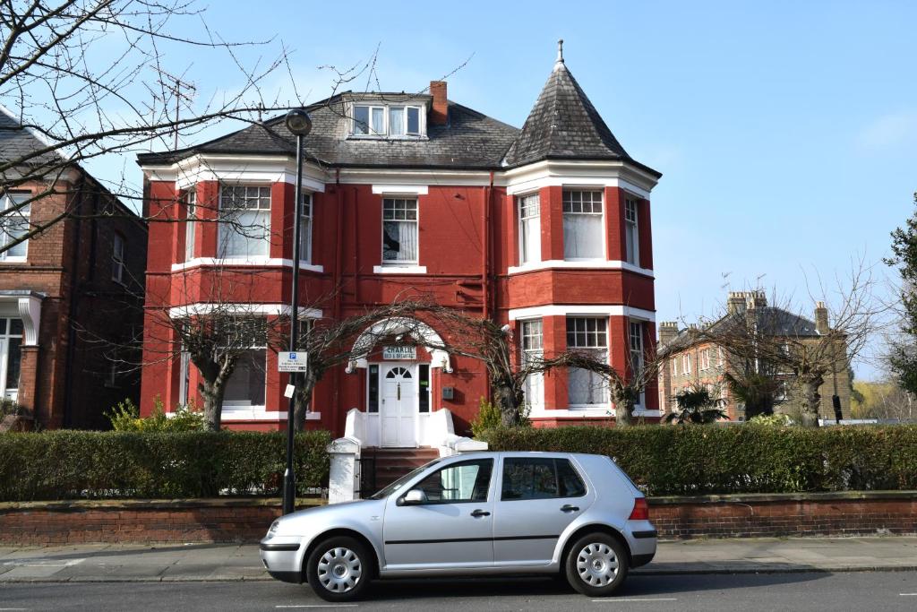 
a white car parked in front of a white house at Charlie Hotel in London
