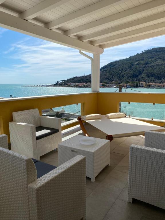 uma varanda com cadeiras e vista para o oceano em Maison Del Magra em Ameglia