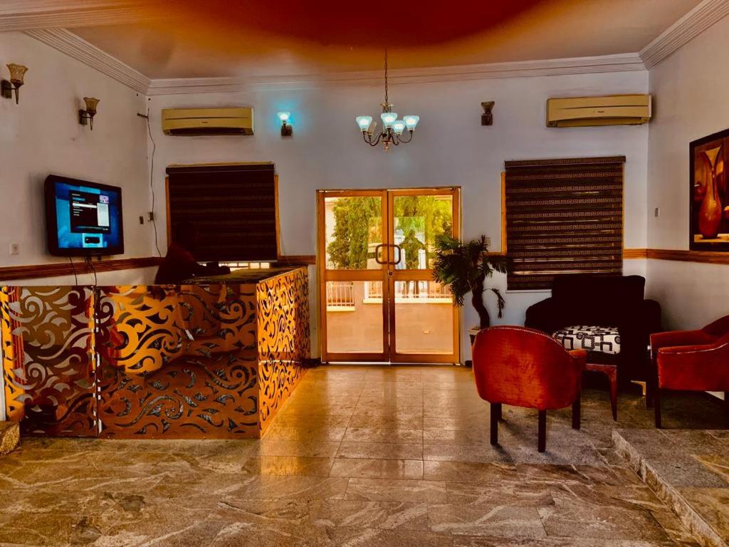E-Gold Luxury Hotel, Maitama في أبوجا: غرفة معيشة بها أريكة وتلفزيون