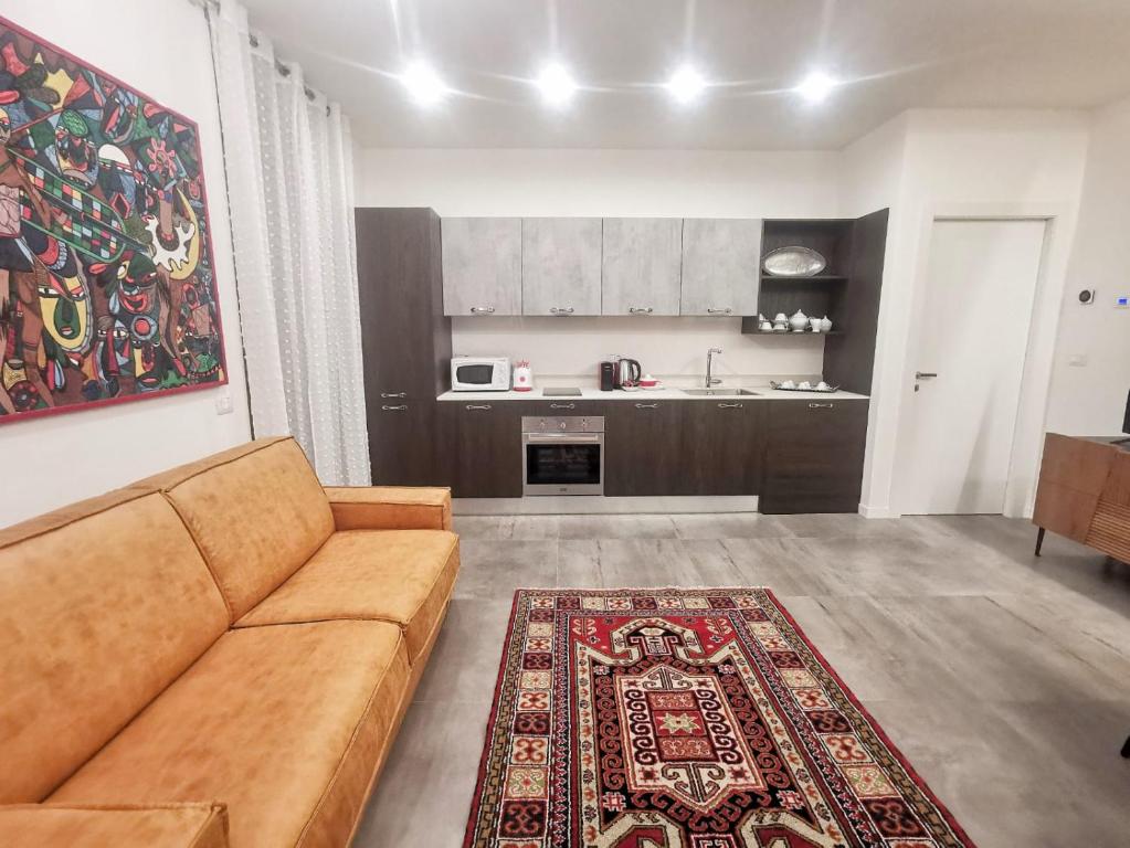 uma sala de estar com um sofá e uma cozinha em Rooms Corso Porta Nuova em Verona