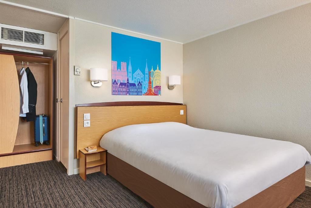 - une chambre avec un grand lit dans une chambre d'hôtel dans l'établissement Kyriad Direct Soissons, à Soissons