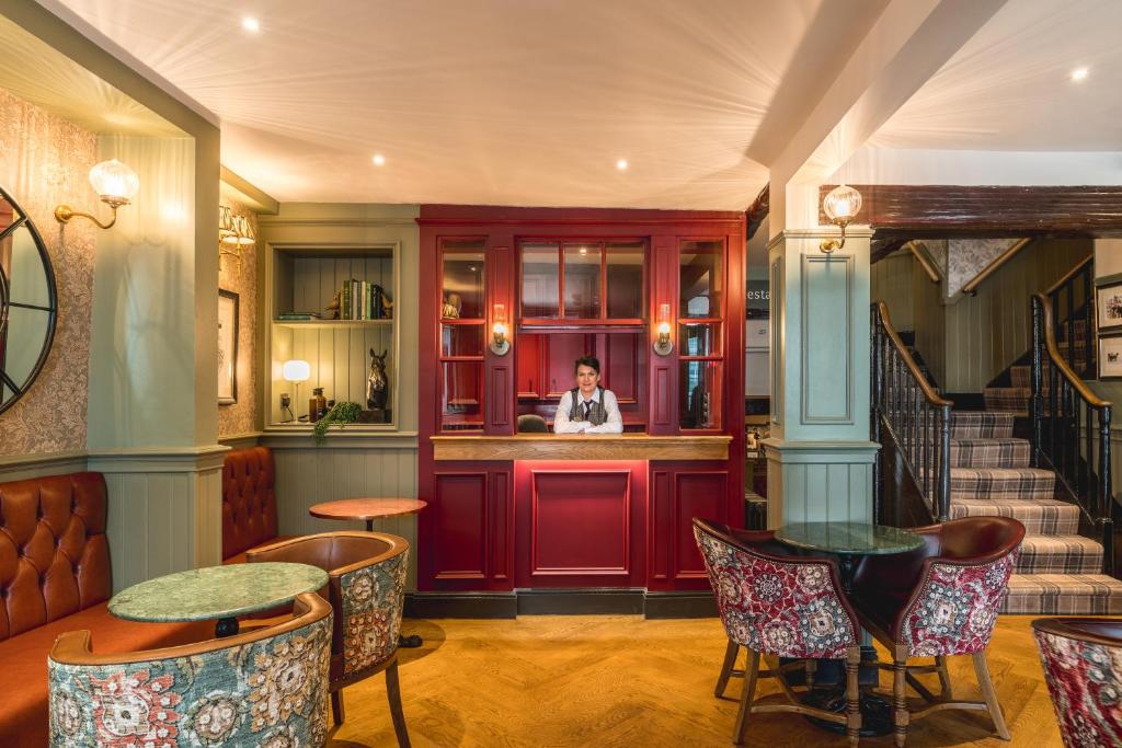 a man standing in a bar in a restaurant at The Kings Arms Hotel in Keswick