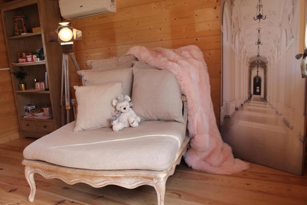 un orsacchiotto seduto su una sedia in una stanza di Chambre élégante dans chalet SDB partagée à proximité a Chavagne