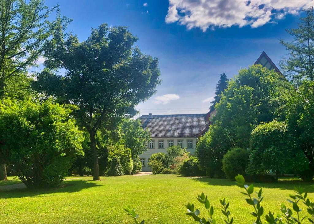 a house in the middle of a green yard at Schloss Sennfeld - Schloss Akademie & Eventlocation - in Adelsheim
