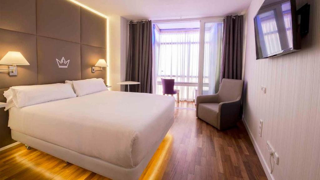 a hotel room with a large white bed and a chair at Erase un Hotel in Madrid