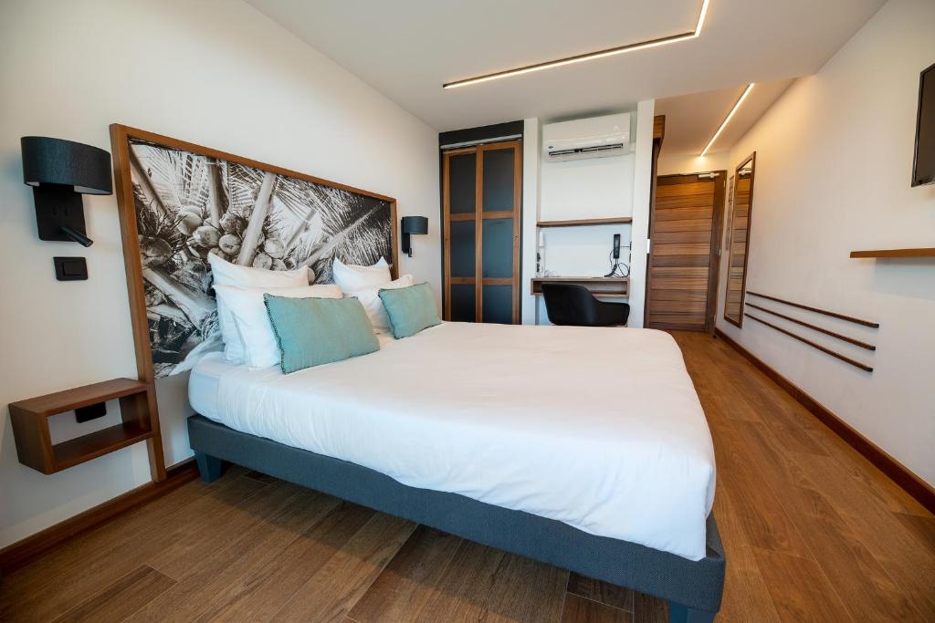 a bedroom with a large white bed with blue pillows at Latitude 21 in Saint-Gilles-les-Bains