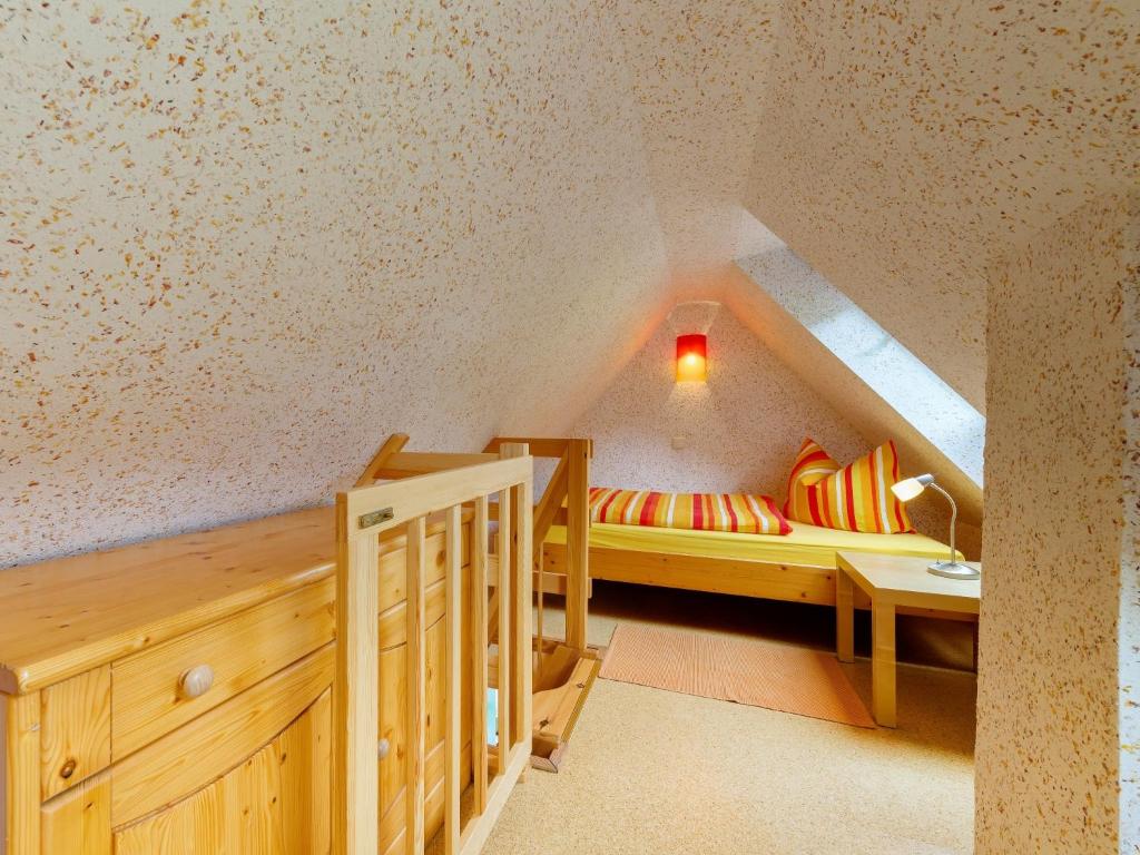 シュヴァルツェンベルクにあるFerienwohnungen Weißflogのベッドとテーブル付きの屋根裏部屋