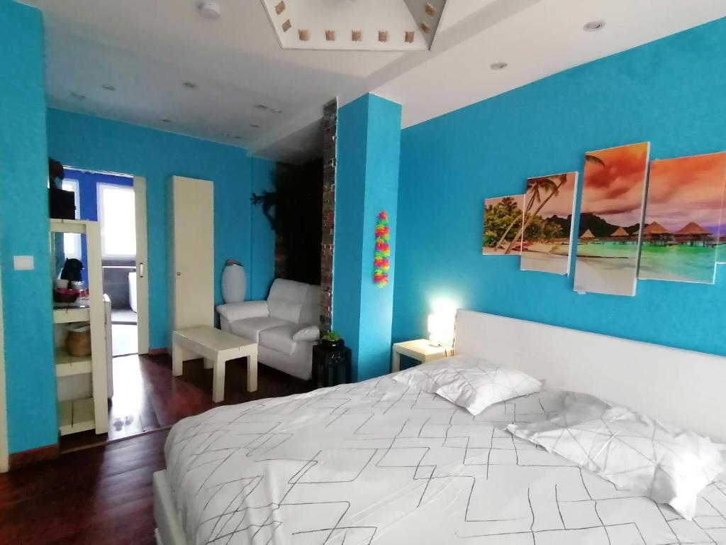 1 dormitorio con paredes azules y 1 cama blanca en L'Odyssée VILLA ILOA, en Dommartemont