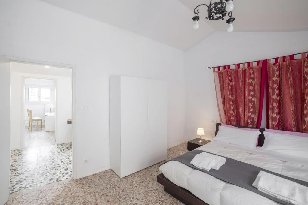sypialnia z łóżkiem z czerwoną zasłoną w obiekcie Ca Rosalba by Venicevillas w Wenecji