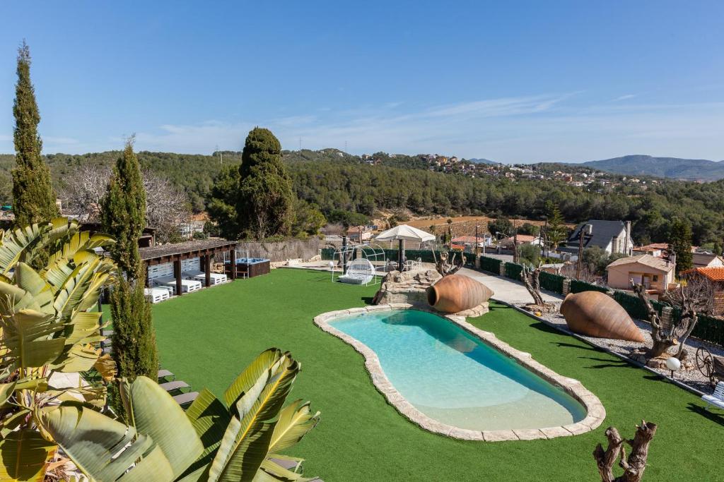 a pool in a yard with a green lawn at Masía Can Trabal in Olerdola