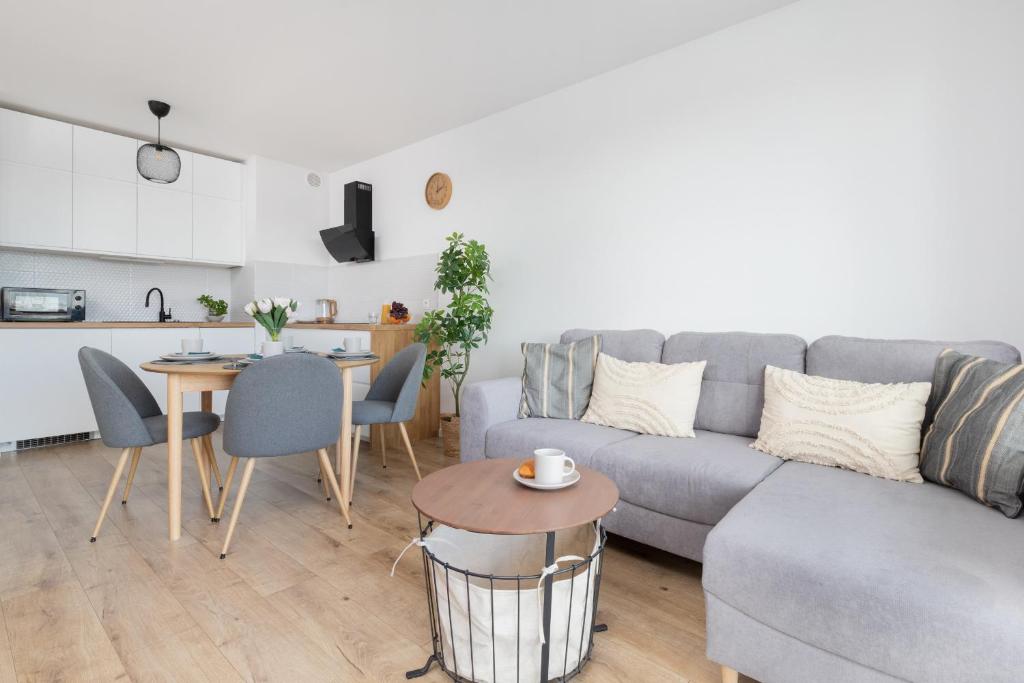 een woonkamer met een bank en een tafel bij Osiedle Latarników Apartment Gdańsk by Renters in Gdańsk