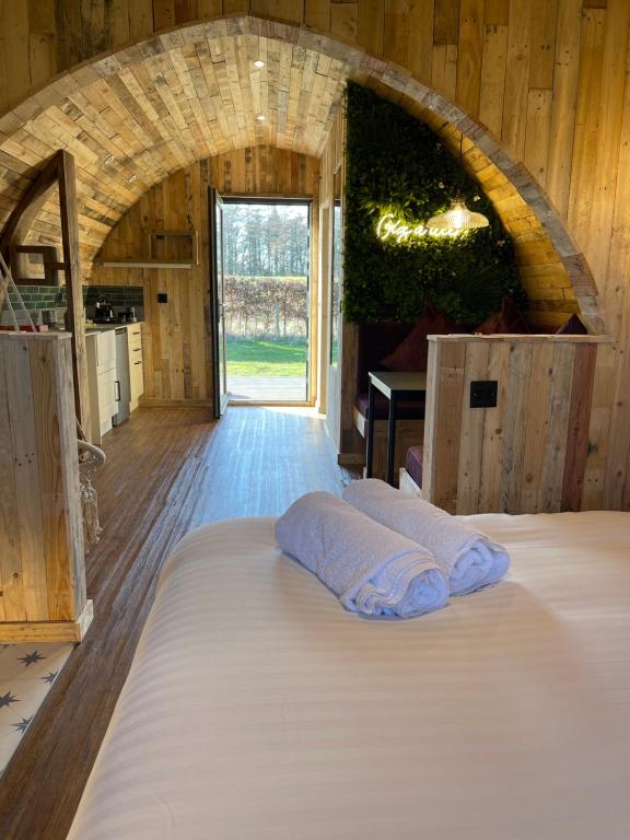 duże łóżko w pokoju z dużym oknem w obiekcie Doxford Farm Camping w mieście Alnwick