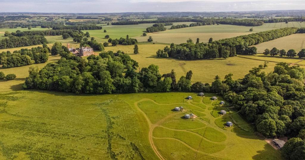 an aerial view of a field with trees and houses at Wild Meadow, Lodge Farm, East Raynham in Fakenham