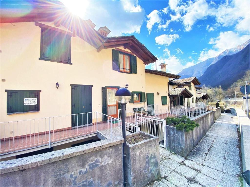 a house in the mountains with the sun shining at Lovely holiday home in Valbondione with balcony in Valbondione
