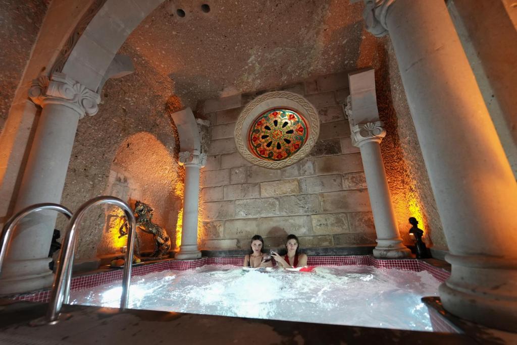 duas mulheres numa banheira de hidromassagem num edifício em Pegas Cave Suites em Ürgüp