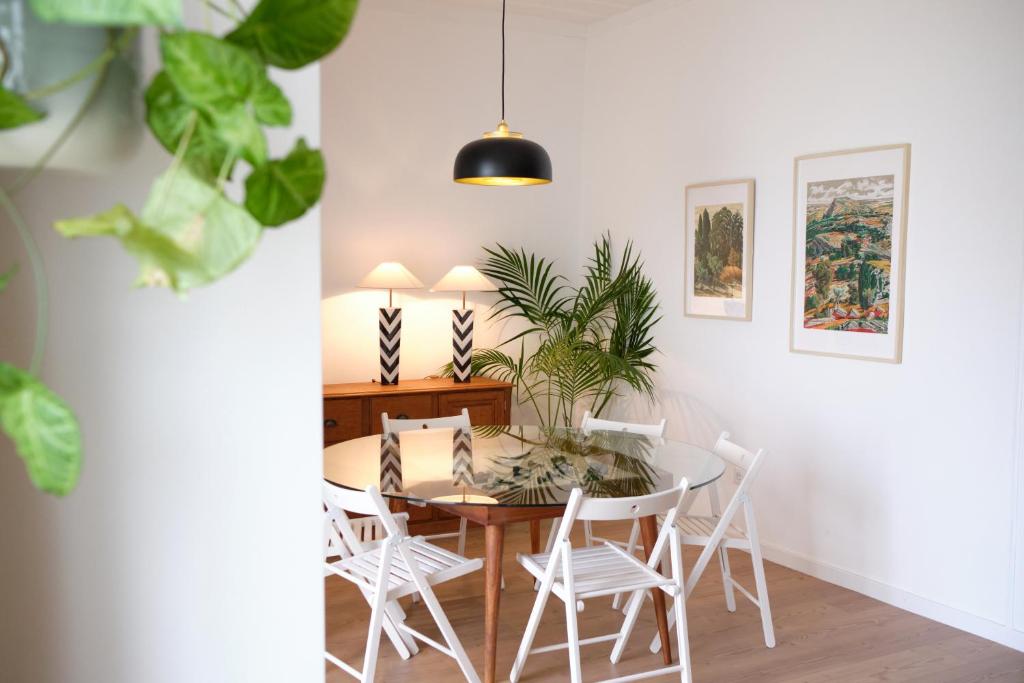 a dining room with a table and white chairs at Ti Noémia - casa de vila in Minde