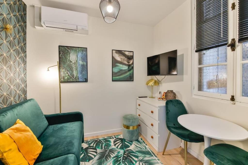 een woonkamer met een groene bank en een tafel bij 0#Studio 2pers#Champs Elysées#Arc de Triomphe in Parijs