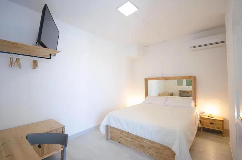a bedroom with a bed and a tv on a wall at Villa degli Alberi in Buseto Palizzolo